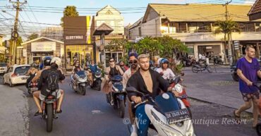 Unregulated tourist scooter rental ban in Bali illustrated by foreigners riding a moped without safety helmets.