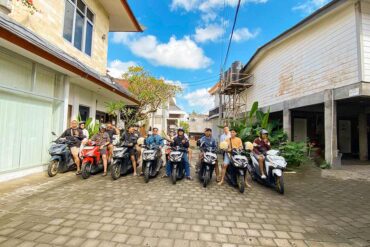 A group of Indonesian domestic tourists posing on their motorbikes at Tunjung Boutique Resort before starting their Bali touring road trip.