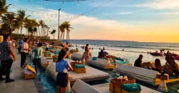 Crowds of Asian travelers enjoying the beach party vibe at Atlas Beach Club during their stay in Canggu.