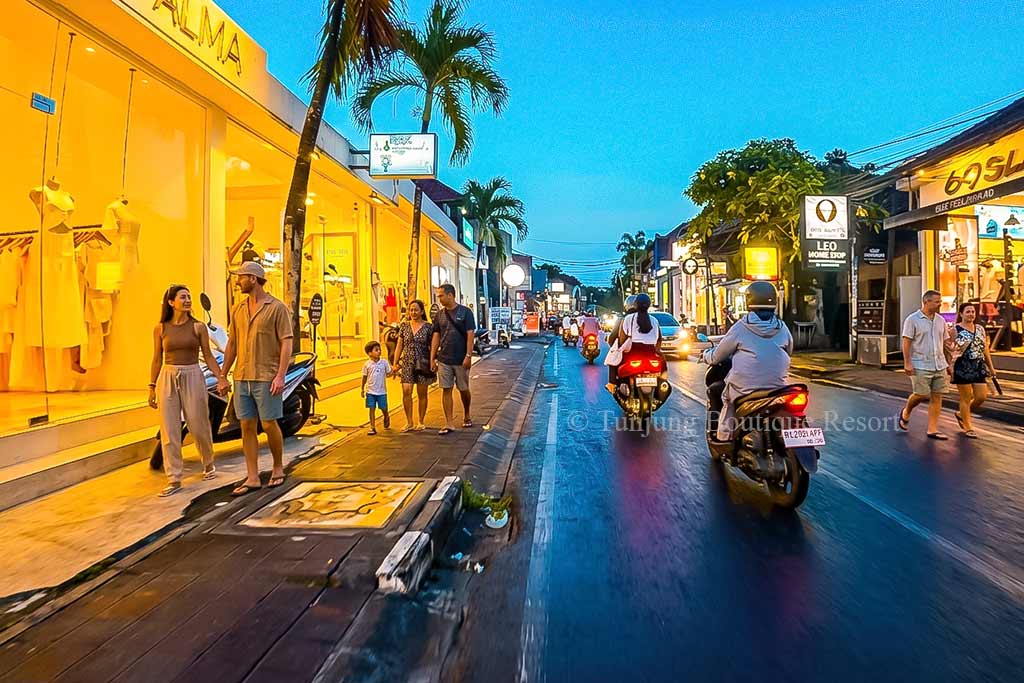 Asian travelers walking along lively Canggu night streets during their holiday stay in Canggu.