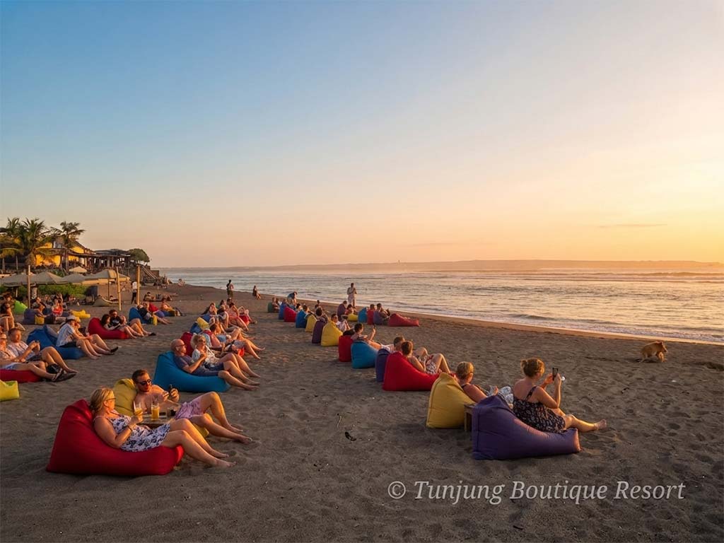Sunny afternoon crowd relaxing on beach beanbags during a vibrant weekend in Canggu Bali.