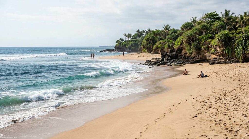 Scenic Canggu coastline with golden sand, ocean waves, and tropical green cliffs.